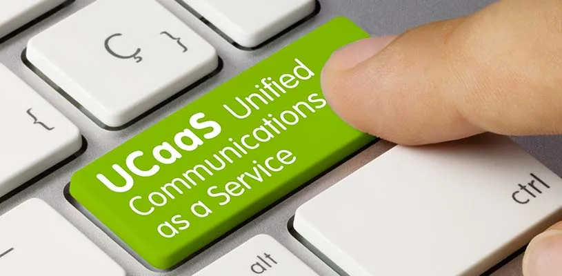 Un dedo pulsa una tecla verde del teclado con el texto UCaaS Unified Communications as a Service
