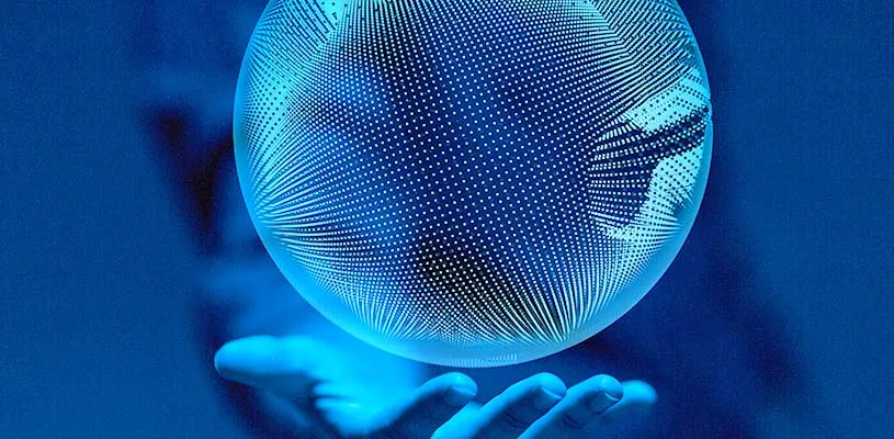 Una mano sostiene un globo luminoso de puntos sobre un fondo azul, símbolo de la comunicación global en red